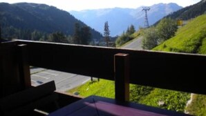 A view from a balcony overlooking a mountain road with greenery and power lines. - Vacations in Belle Plagne at the foot of the slopes (Saturday to Saturday rentals) (Belle-Plagne)