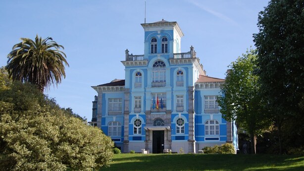 A large, historic building with a symmetrical facade, multiple windows, and a central entrance. - Casa para 5 en el centro de Colombres (Colombres)