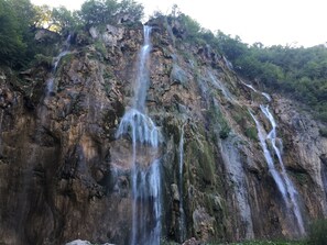 A waterfall cascading down a rocky cliff surrounded by dense forest.