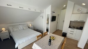 Eine kompakte, moderne Wohnung mit Schlafgalerie, Essbereich und einer Küchenzeile.