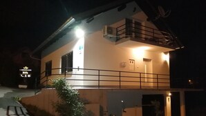 Ein zweistöckiges Gebäude mit Balkon, Treppe und einem Schild, das es als Apartmenthaus für VIP-Gäste kennzeichnet.