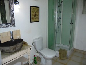 Une salle de bain avec un grand lavabo, des toilettes et une douche à parois de verre.