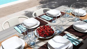 An outdoor dining area with a pool in the background. - Villa with pool surrounded by olive groves. With sea view.Casa in campagna.  (Alghero)