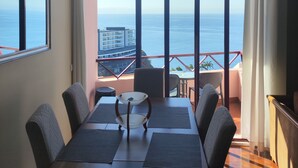Ein Essbereich mit Tisch, Stühlen und Blick auf den Ozean.
