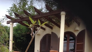 En traditionell byggnad med en trappa klädd i kakel, en pergola och stora terrakottakrukor.