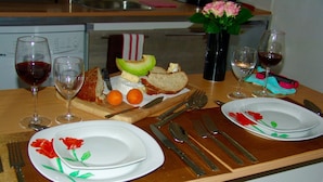 A dining table set with plates, cutlery, glasses, and a fruit platter. - Studio in the Medieval Center of Sarlat (FRANREAL) (Sarlat la Caneda)