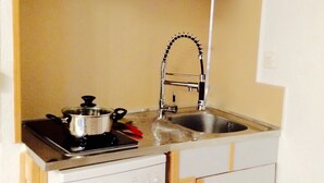 Cocina compacta con estufa, lavaplatos y lavamanos.