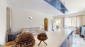 A spacious living area with a sofa, a coffee table, and decorative pine cones.