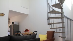 A modern living space with a spiral staircase, a dining area, and a kitchen. - House "Pont Transbordeur" Rochefort city center (Rochefort)