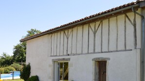 Un bâtiment à deux étages, doté d’un toit recouvert de tuiles, d’un petit porche à l’avant et d’une porte.
