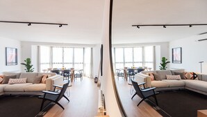 A modern living room with a sofa, chairs, and a dining area with a table and chairs. - Petit Luxe l'Àtic (Terrassa) (Terrassa)