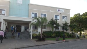 A building with a sign reading "SHERATON" and "babycare" on the facade. -  "A Village Experience" (Oistins)
