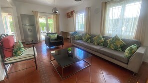 A living room with a sofa, armchairs, a coffee table, and a dining area with a table and chairs. - House Seaside & Pool - Flic en Flac (B) (Flic en Flac)