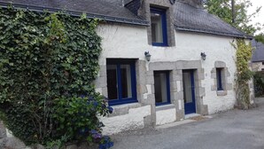 A stone building with three windows, each with a blue frame. - House with heated indoor swimming pool  (Évellys)