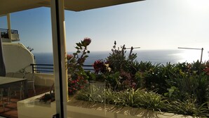A balcony with a view of the sea, potted plants, and outdoor furniture. - Esmee Apartment, Big Terrace with Sea View! (Arco Da Calheta)