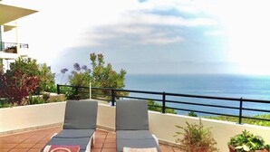 Two lounge chairs on a tiled terrace with a view of the sea. - Esmee Apartment, Big Terrace with Sea View! (Arco Da Calheta)