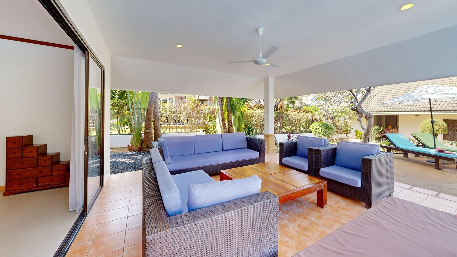 A spacious outdoor living area with a sofa, two armchairs, and a coffee table.