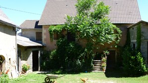 A courtyard with a wheelbarrow, chickens, and a house with a tiled roof. - Farm cottage in activity  (Vaureilles)