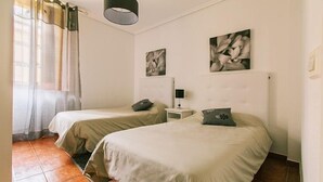 A room with two beds, a nightstand, a lamp, and artwork on the wall. - Rural house (full rental) Centro Río Lobos for 6 people (Hontoria del Pinar)