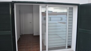 Une pièce dotée d’une porte-fenêtre coulissante donnant sur un balcon.