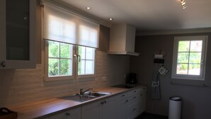 Een moderne keuken met een groot raam, een inbouwspoelbak en een koffiezetapparaat.