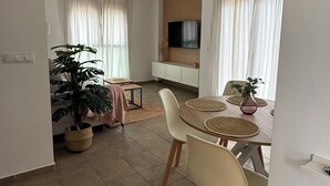 Un coin repas avec une table ronde, des chaises et un ventilateur de plafond.