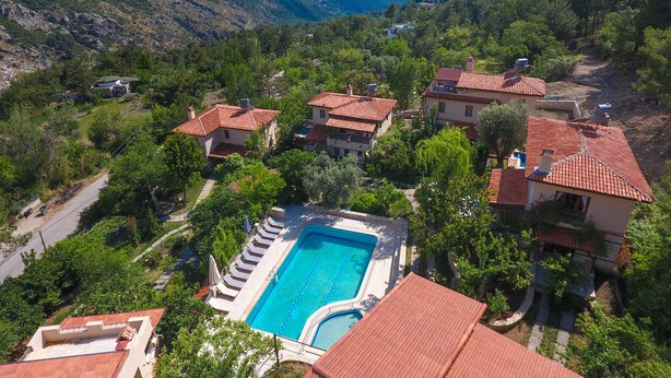 Un complexe hôtelier doté d’une piscine, de maisons en terrasses et offrant une vue sur les montagnes.