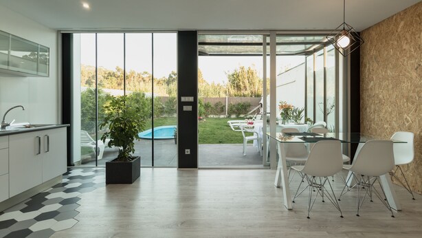 A modern kitchen with a large sliding glass door leading to a backyard with a pool and outdoor seating. - House with garden and pool 5 minutes from the beaches (boiro)