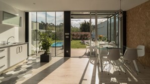 A modern kitchen with a glass door leading to a backyard. - House with garden and pool 5 minutes from the beaches (boiro)