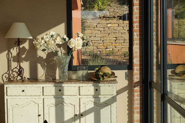 A white dresser with a vase of white flowers, a lamp, and a glass container. - Magnificent ancient farm that has been reformed. Exceptional location in Cassis (Cassis)