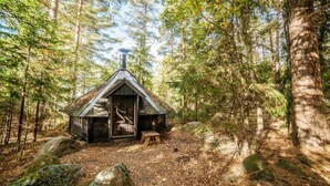 A small wooden cabin with a sloped roof, surrounded by a forest. - Skitunäs Seaside villa in Pyhtää (Pyhtää)