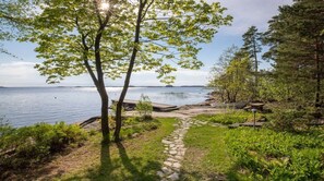 A pathway leading to a lakeside area with a wooden deck and a stone path.
