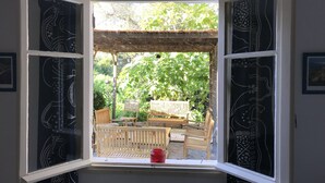 A room with a bay window overlooking a garden. - Golfe Ajaccio sud La Castagna: Charming waterfront home! (Coti-Chiavari)