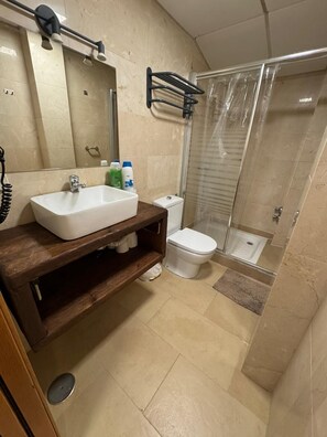 Een douche, handdoeken, zeep, shampoo