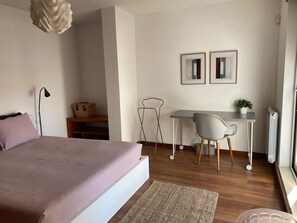 2 habitaciones, escritorio y tabla de planchar con plancha