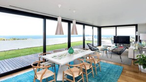 Un comedor moderno con una mesa grande, sillas y vista al agua.