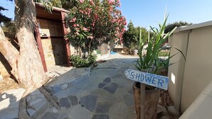 A stone pathway leading to a wooden door with a 'SHOWER' sign.