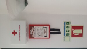 A first aid kit, a red emergency blanket, and two cards with safety symbols.