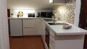 A compact kitchen with a dishwasher, microwave, stove, and sink.