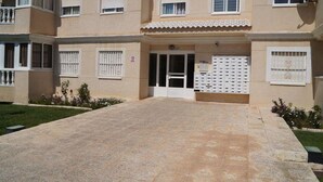 Un bâtiment doté d’une entrée centrale, de nombreuses fenêtres et d’un petit jardin.