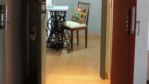 Un pasillo estrecho que conduce a un comedor con una mesa y una silla.