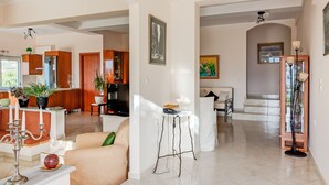 Amplia sala de estar con cocina, comedor y escalera que conduce a un nivel superior.