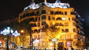 Un edificio de varios pisos con un diseño arquitectónico singular, que cuenta con balcones y una terraza en la azotea.
