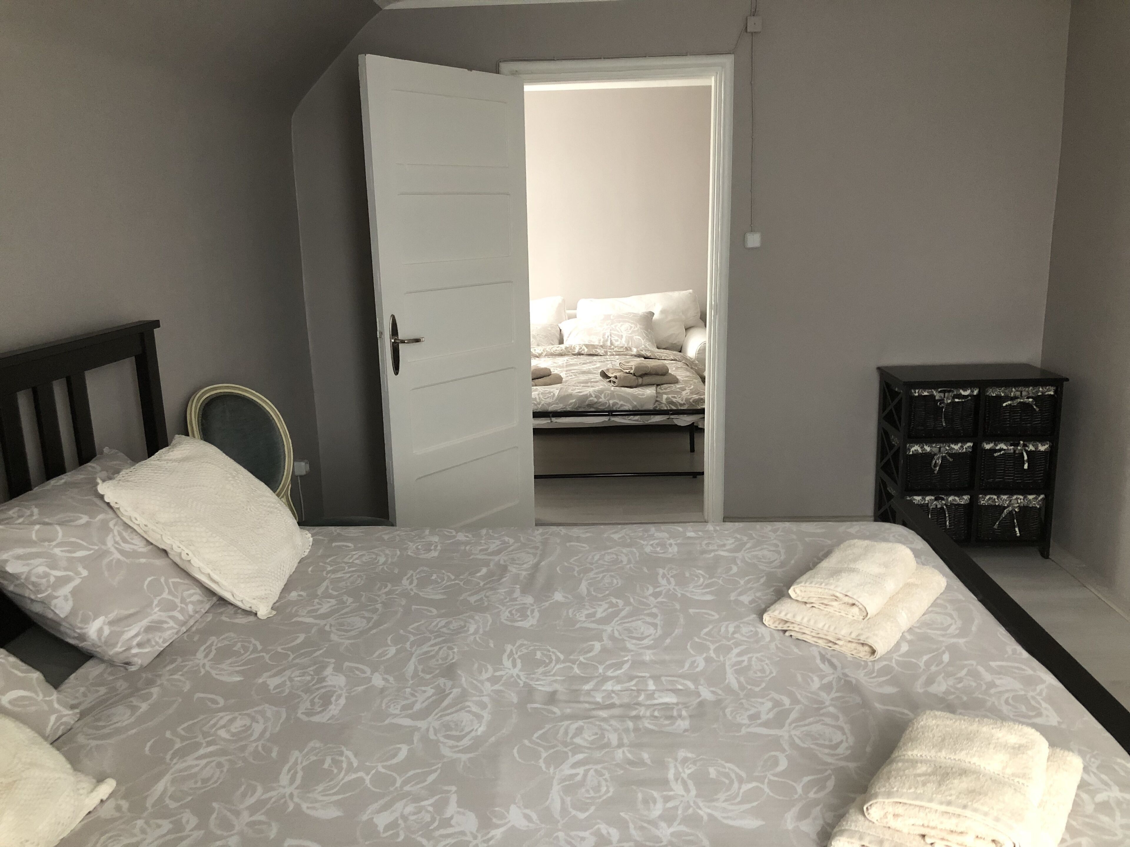 Ein Schlafzimmer mit einem Bett, einem Kleiderschrank und einer Tür zu einem anderen Raum.