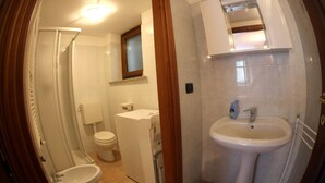 Un baño con inodoro, bidé, lavabo y espejo.