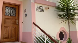 A building with a wooden door, a staircase with a white railing, and a sign reading "CASA CLARA".