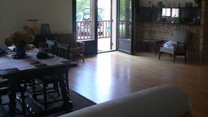 Amplia sala de estar con una mesa de comedor, sillas, un sofá y una chimenea.