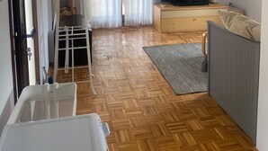 A living room with a wooden floor, a TV, a painting, and a sofa. - Peaceful holidays for an active family (Stari Grad)