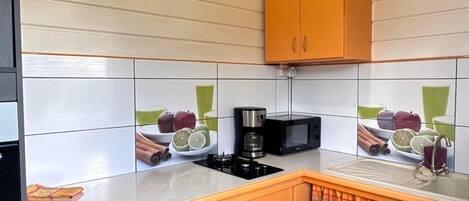 A kitchen with wooden cabinets, a microwave, and a gas stove.