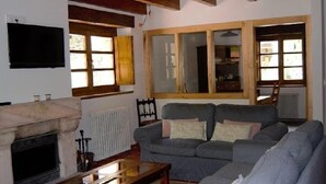Uma sala de estar com lareira, sofá e televisão.